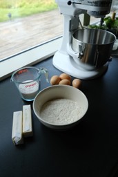 ingredients on counter including butter, eggs, flour, sugar and stand mixer